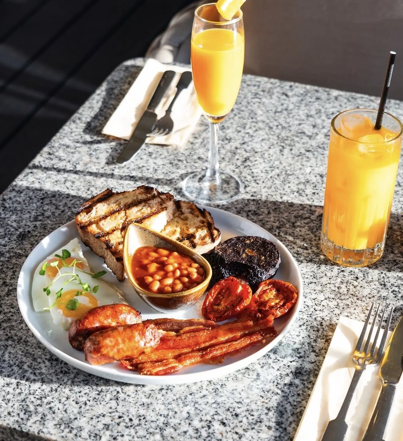 Full English breakfast with fresh orange juice in the sun